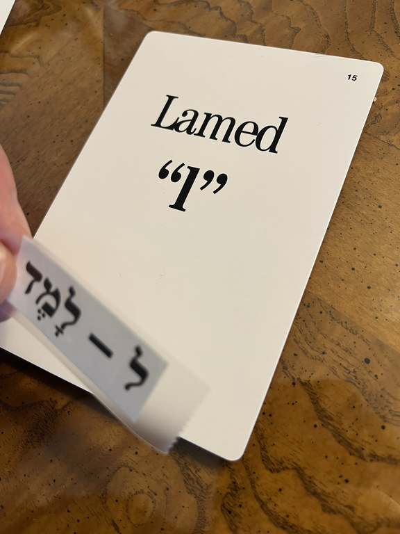 Lamed flashcard while the Hebrew name label is being attached